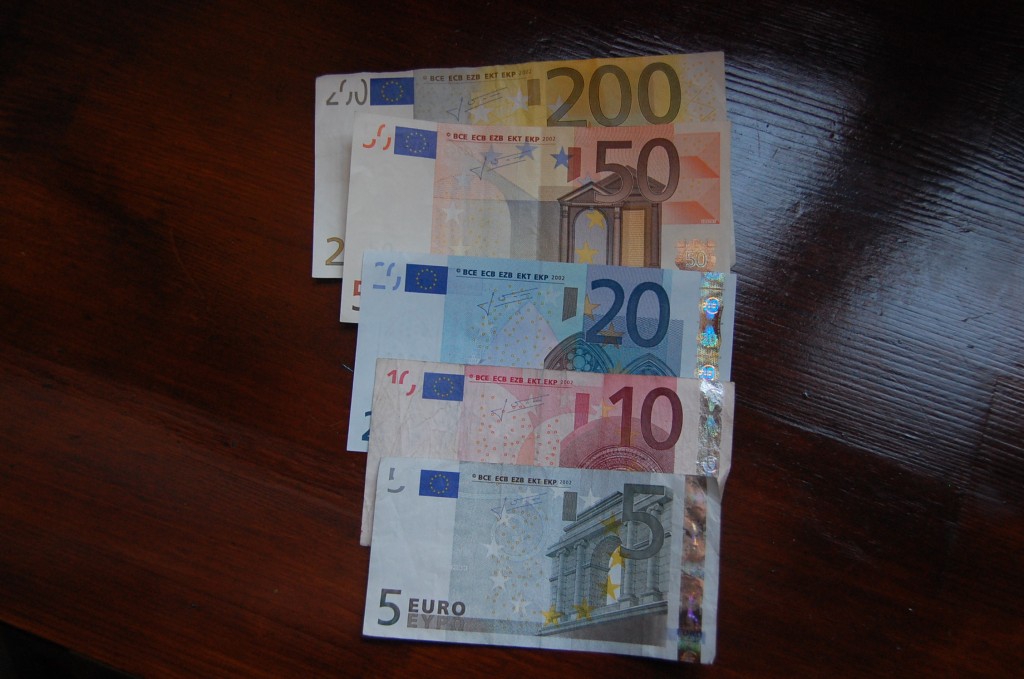 Euro bills on a table lined up to show size