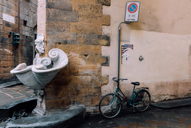 bike parked by a fountain in florence