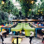 garden restaurant Madre in Rome with hanging plant rows on ceiling, living plant wall and bright green couches