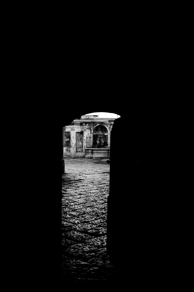 small view of an old wall and fountain surrounded by darkness in Salerno Italy