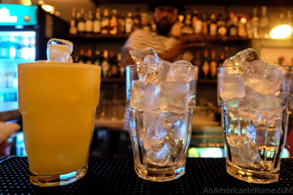 Three drinks being prepared at Bar del Fico with the bartender shaking another in the background