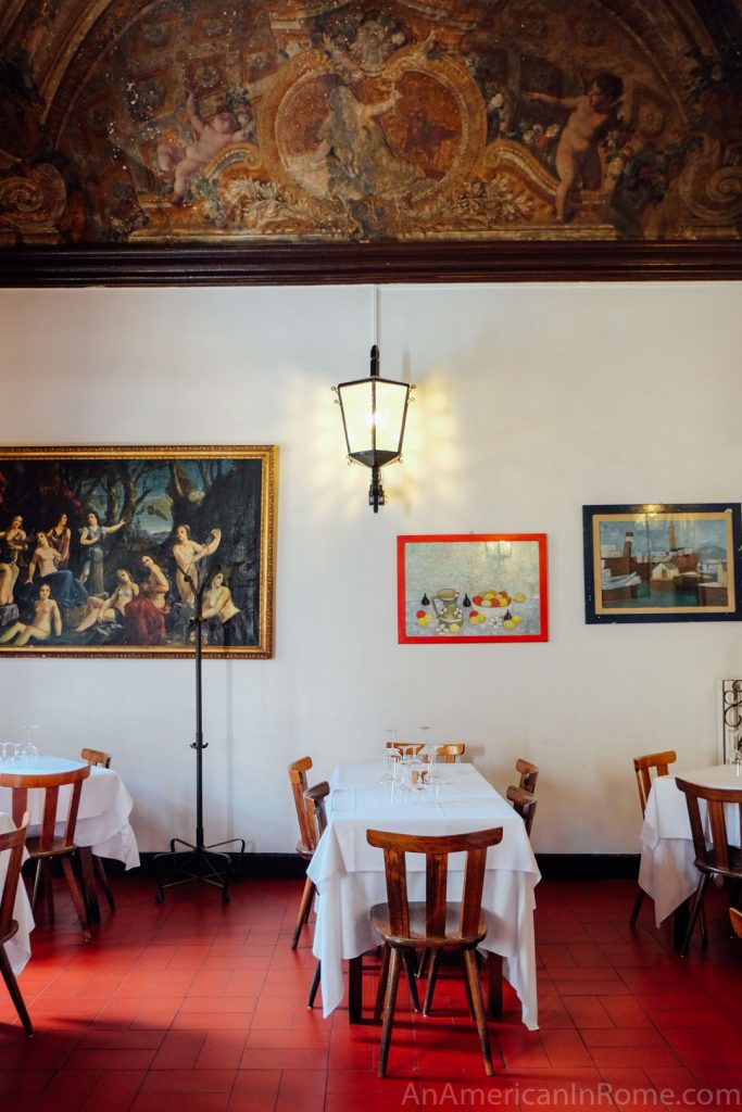 frescoes and tables inside Al Pompiere restaurant in Rome