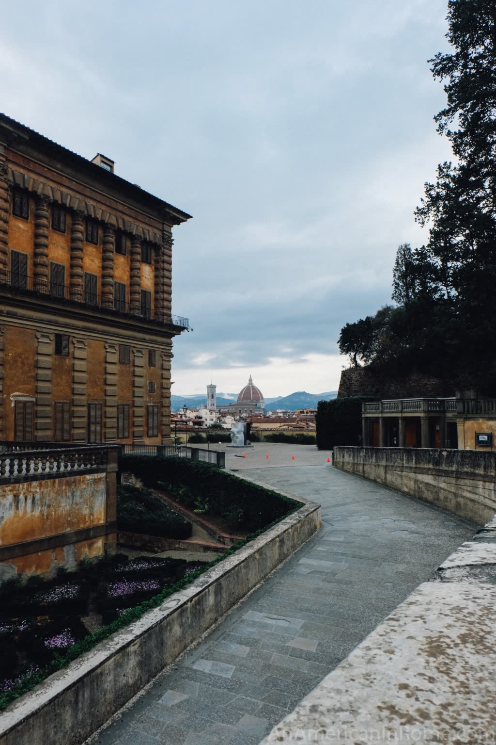 view of duomo from boboli gardens looking down a road