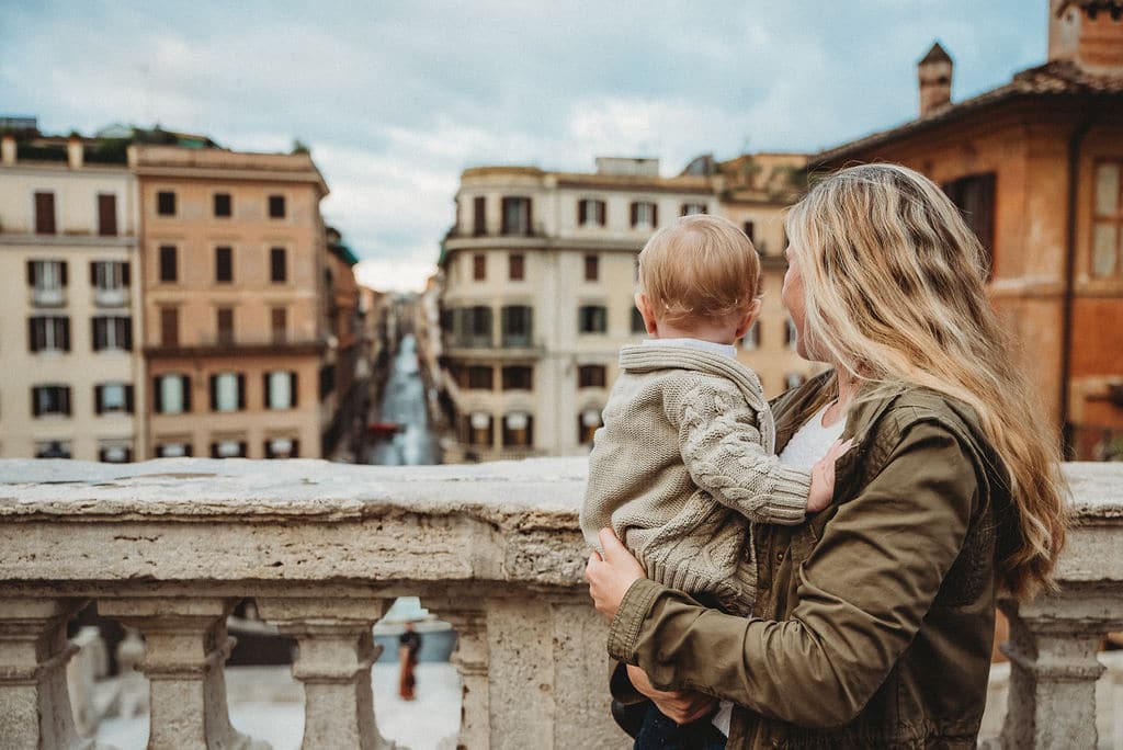 mother and baby turned away from the camera looking at Rome cityscape