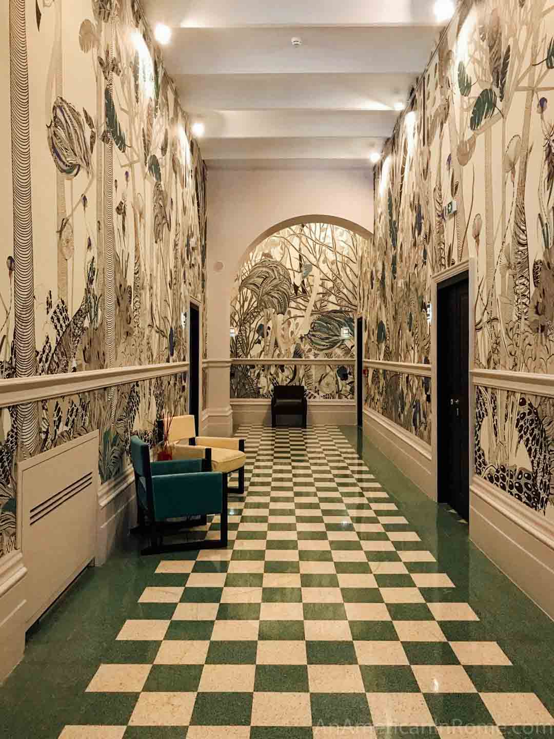 checkered green and white marble floors and patterned wallpaper in hallway at Roma Luxus hotel