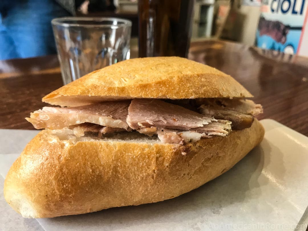 close up of porchetta panino in Rome at er buchetto on golden bread