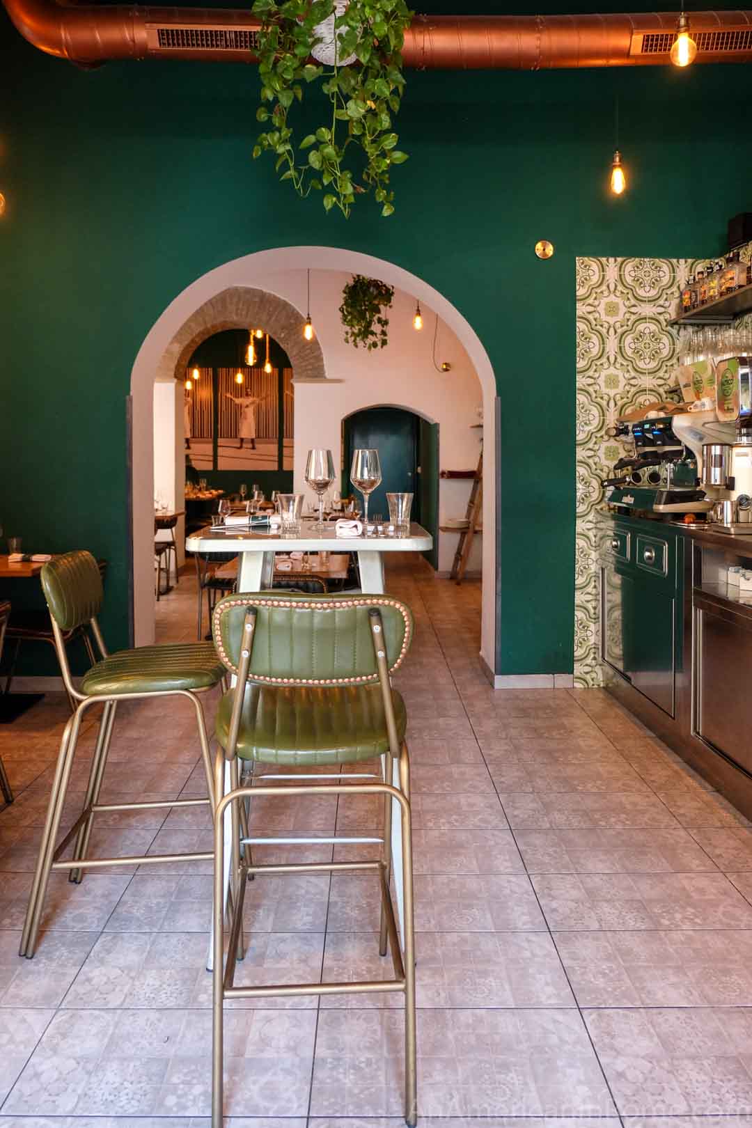 Interior stools and green wall inside Luciano Cucina Italiana restaurant in Rome