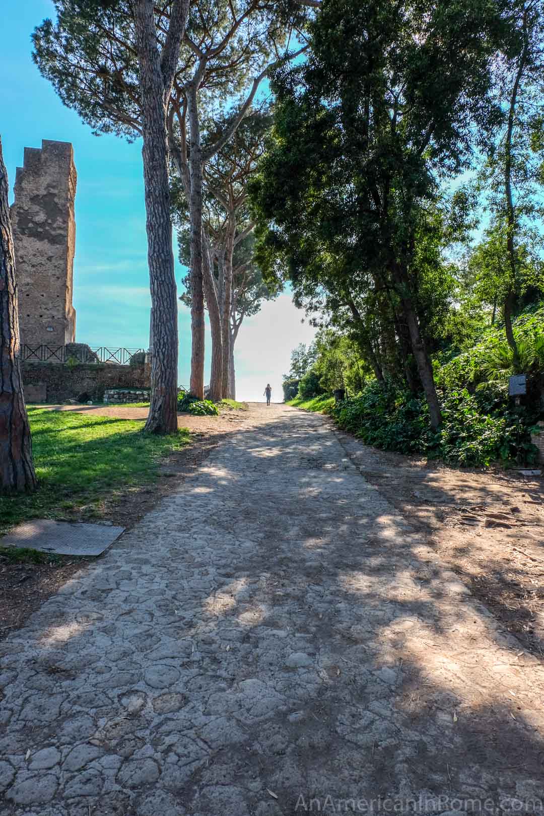 person at the end of a sunny path on the palatine hill