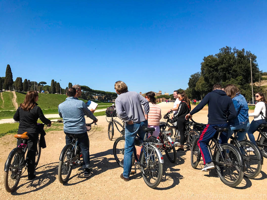 backs of people on bikes on dirt path in Rome