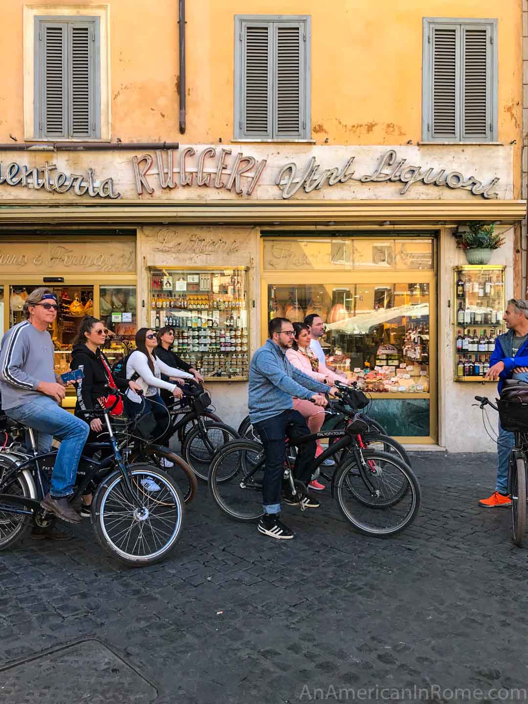 people on bikes in front of an Italian food store