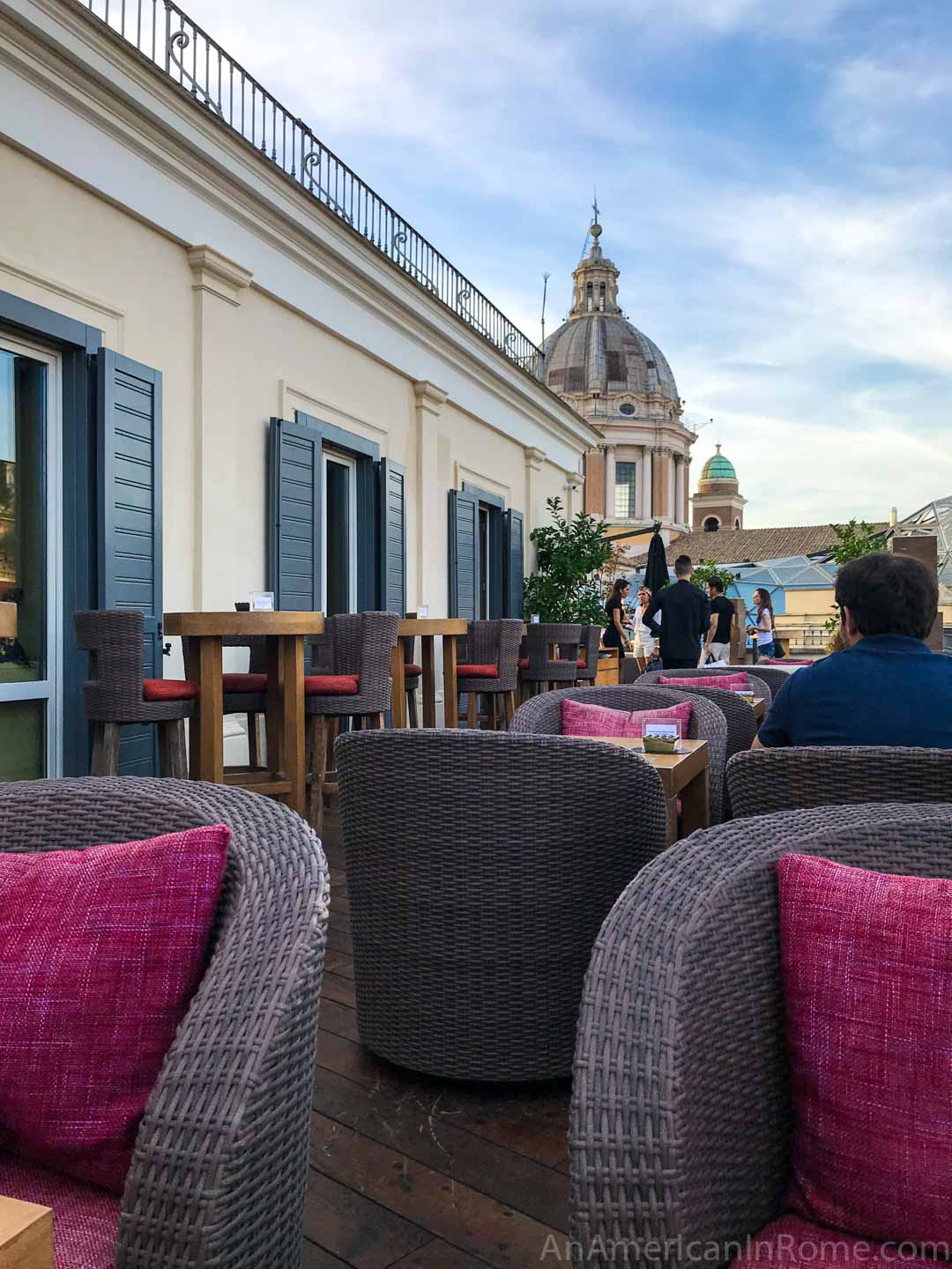 chairs on a rooftop bar with church dome in the background