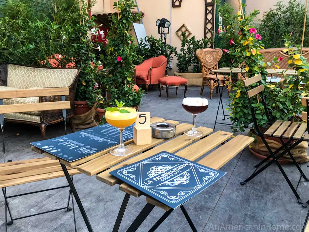 drinks on a table outside with plants and furniture