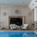 indoor pool in rome with two white chairs