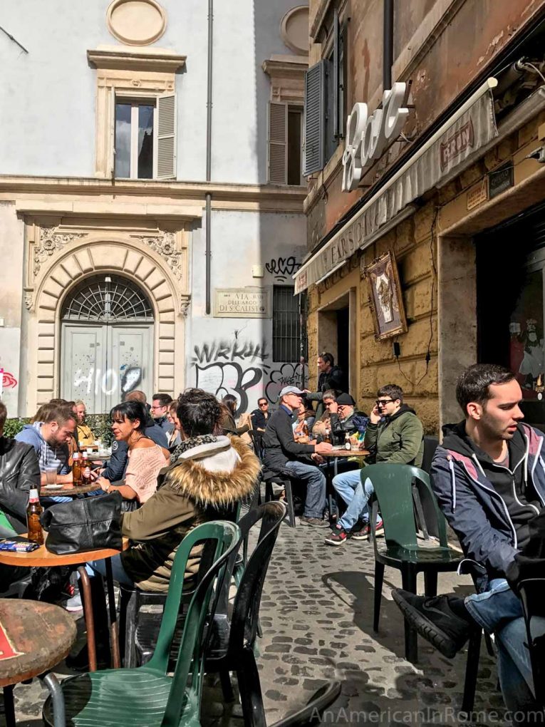 people sitting at an outdoor cafe in rome